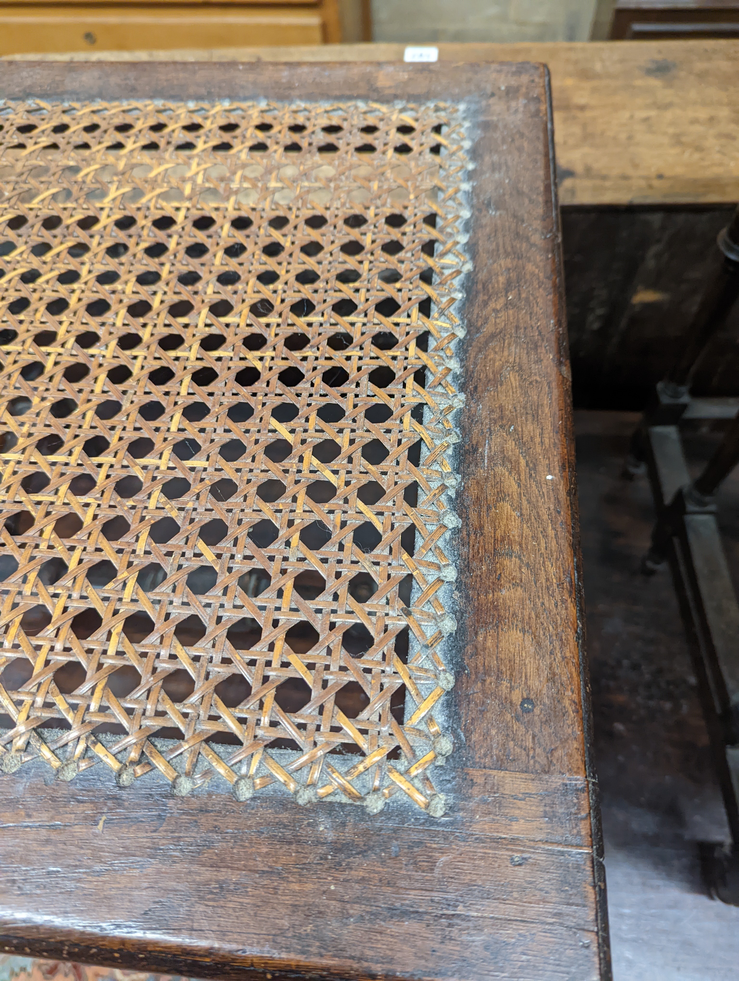 A 17th century style carved oak stool, with caned seat and H stretcher, width 47cm, depth 46cm, height 42cm